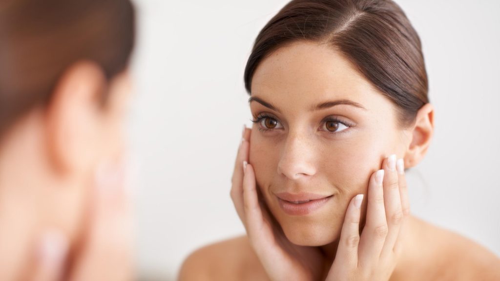 lady with smooth skin looking in mirror